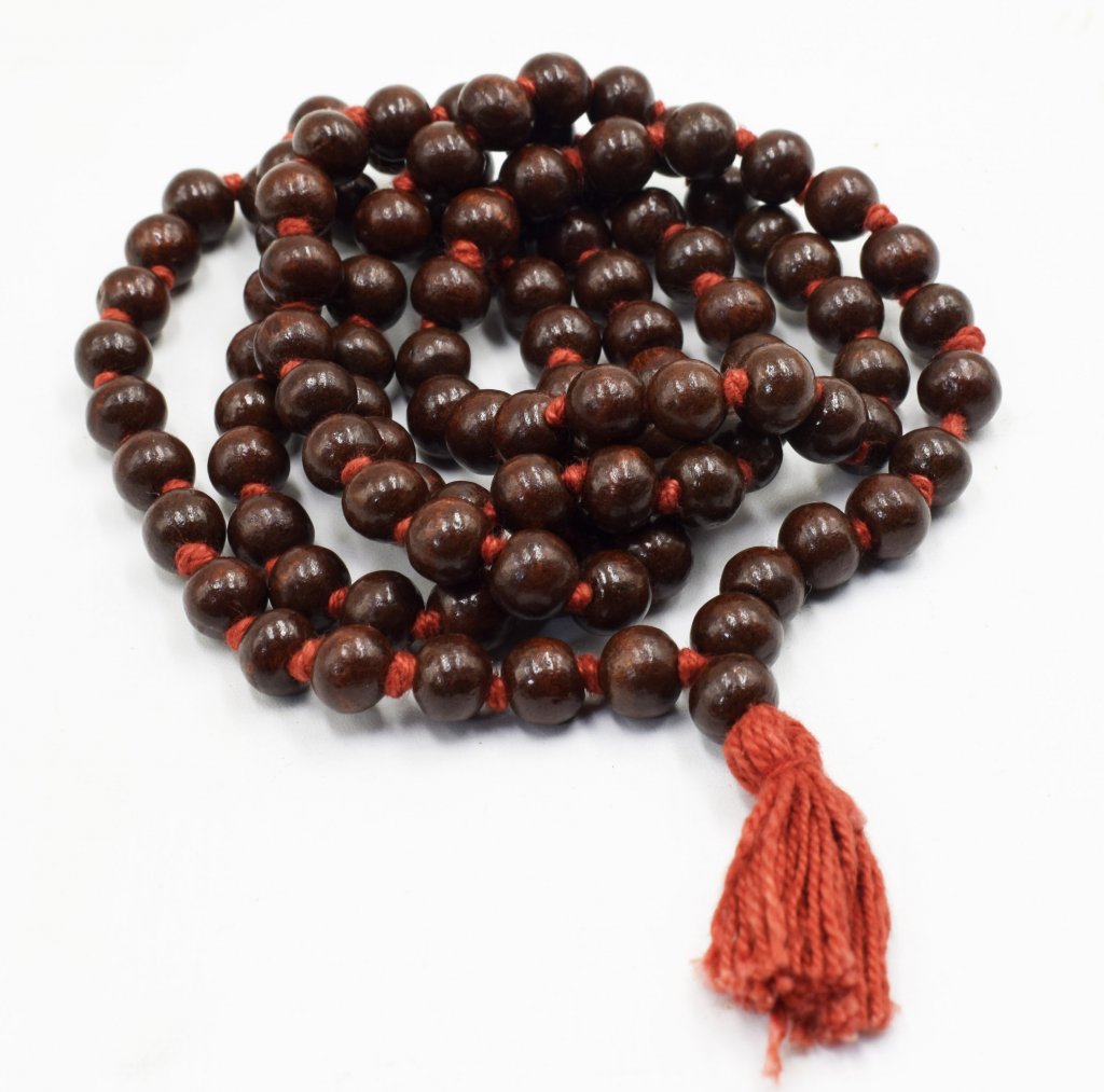 This is a zoom-in picture of a "MALA" of dark red sandalwood(LAL CHANDAN) and, each bead of red sandalwood placed on a plain white background.