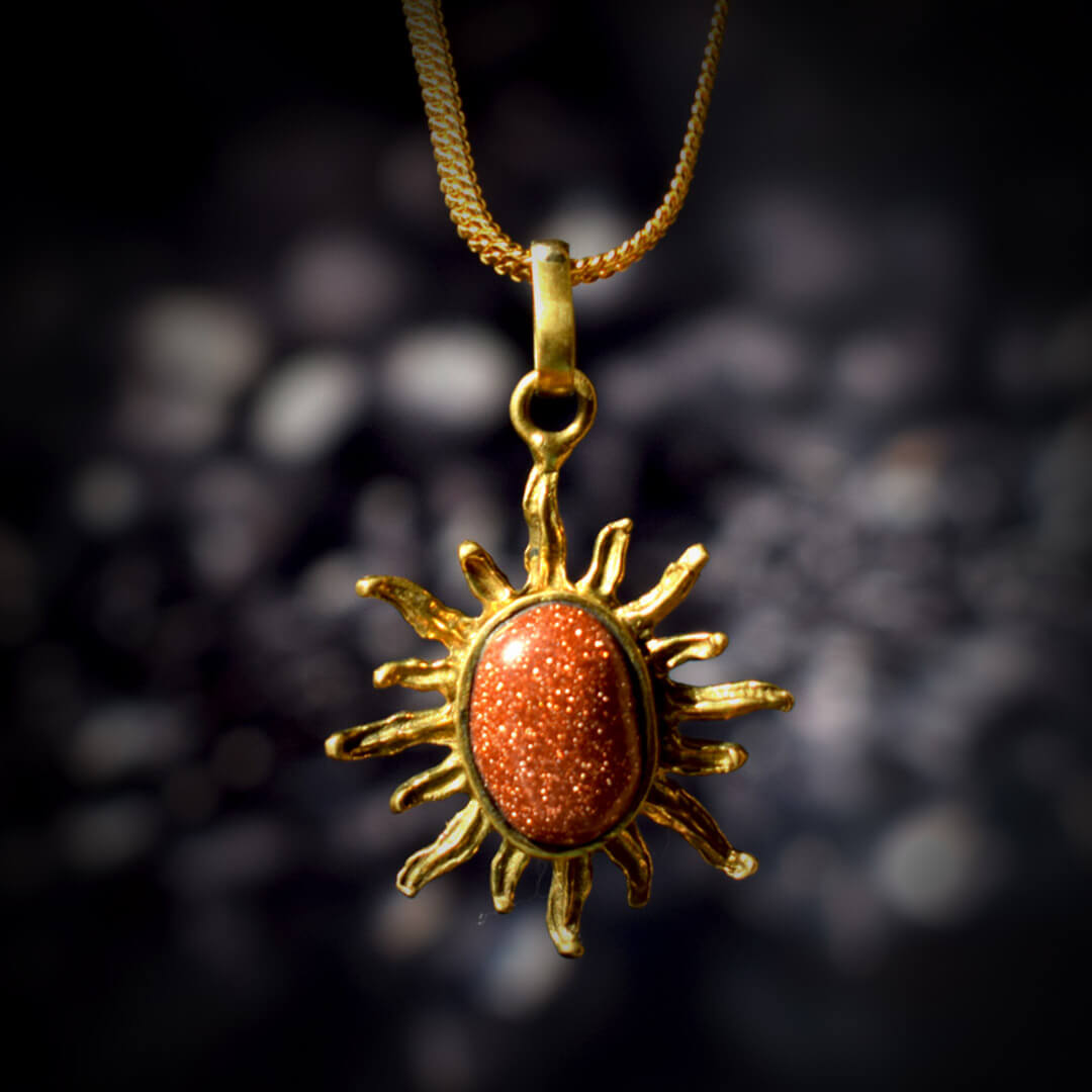 A square Surya Kavach locket with a golden chain hanging over a black stone as shown in the image